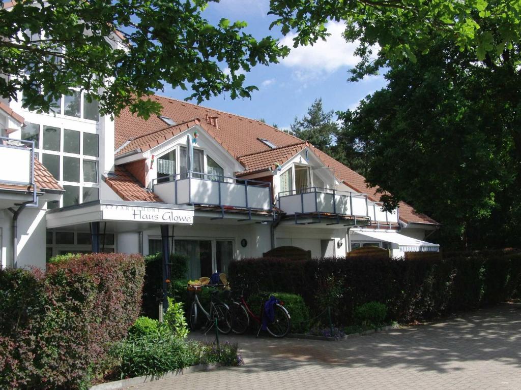 Biały dom z rowerami zaparkowanymi przed nim w obiekcie Appartment Haus Glowe - Wohnung 11 - 300 m zum Strand w mieście Klein Gelm