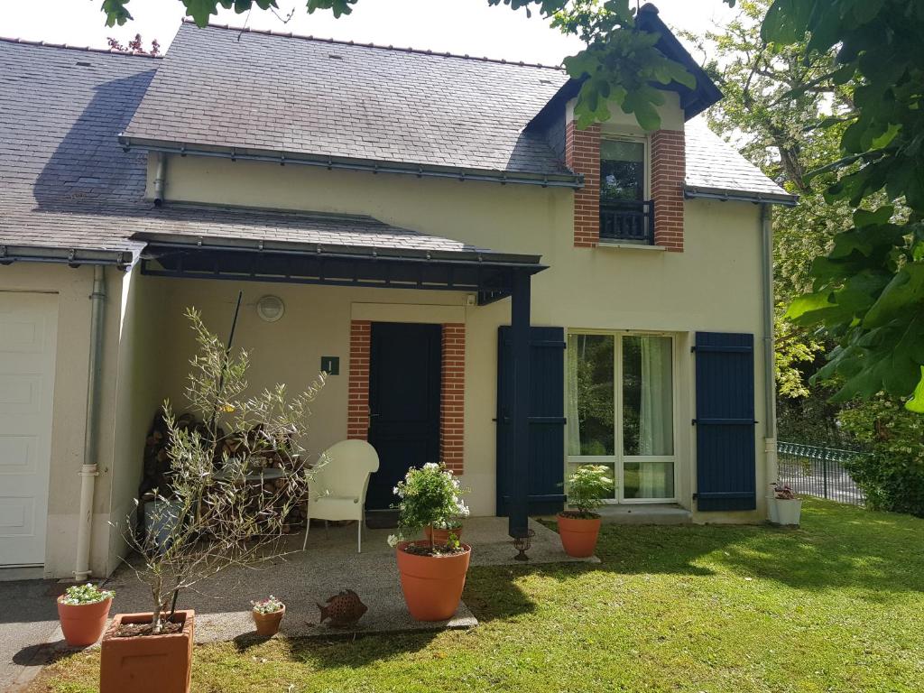 uma casa com uma porta azul e uma cadeira no quintal em Villa Sainte Marguerite em Pornichet