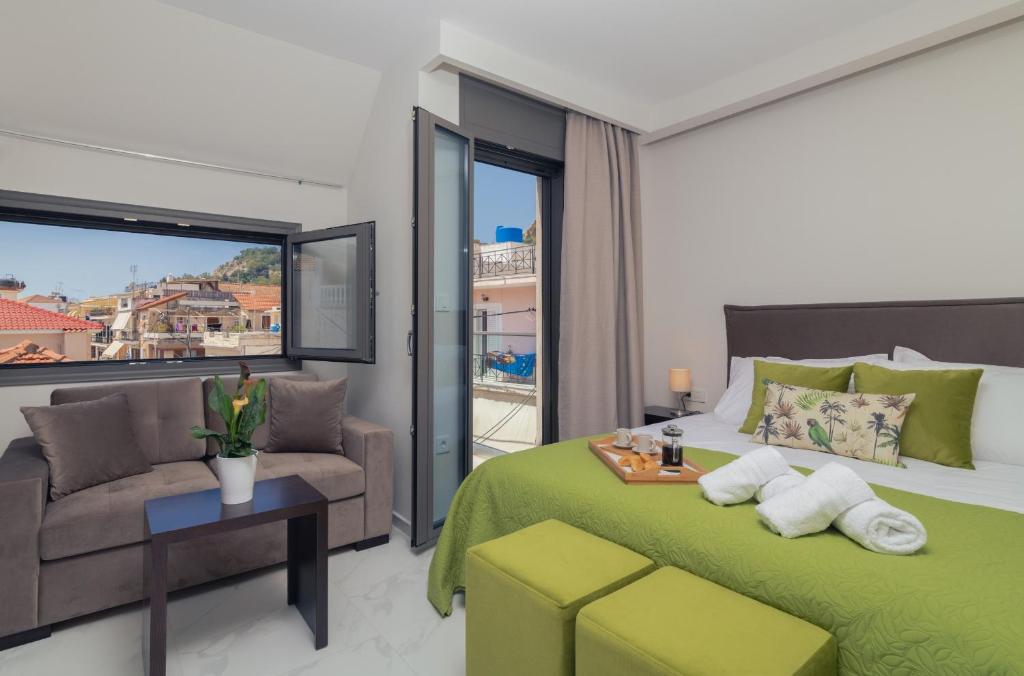 een slaapkamer met een groen bed en een bank bij Centro Studios & Apartments in Zakynthos