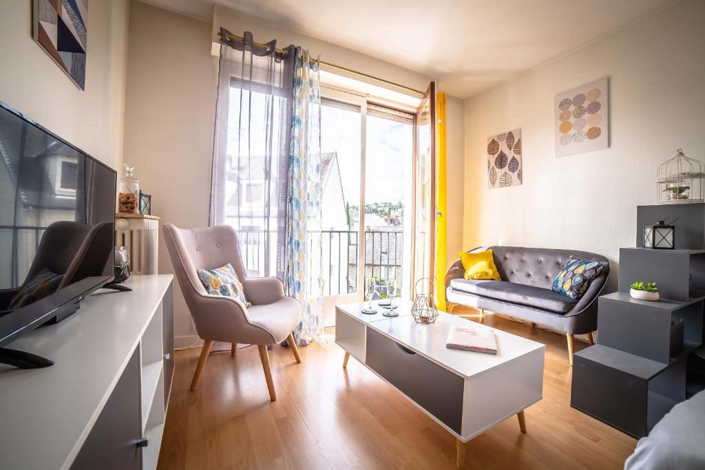 un salon avec un canapé et une table dans l'établissement Le Petit Joyau - 1 Chambre, à Brive-la-Gaillarde