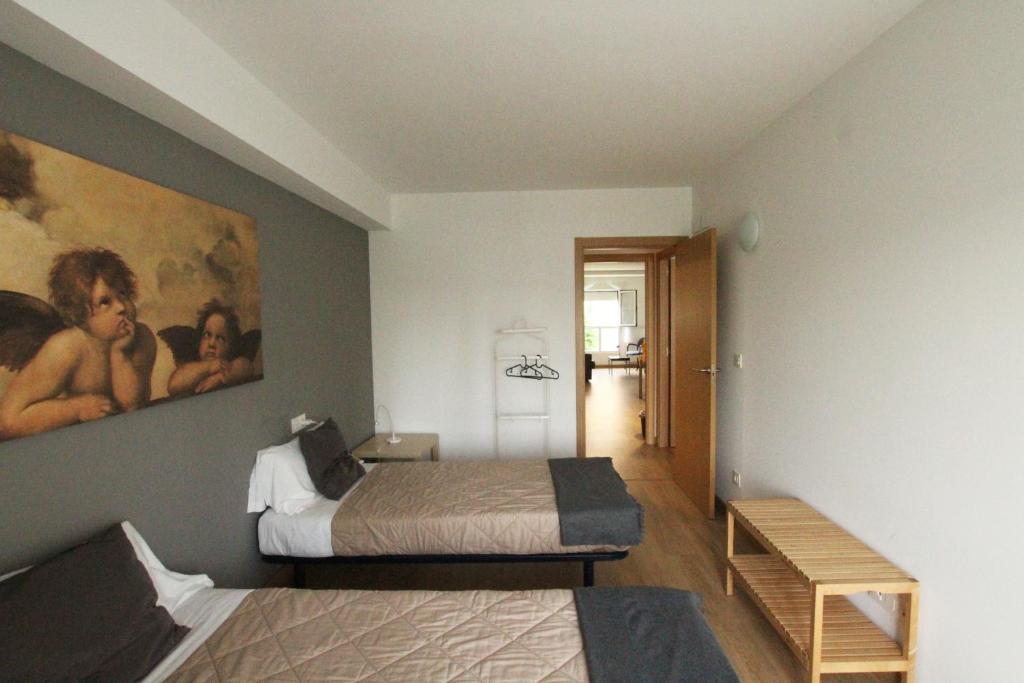 ein Schlafzimmer mit 2 Betten und einem Wandgemälde in der Unterkunft Apartamento Labegain 5 in Sestao
