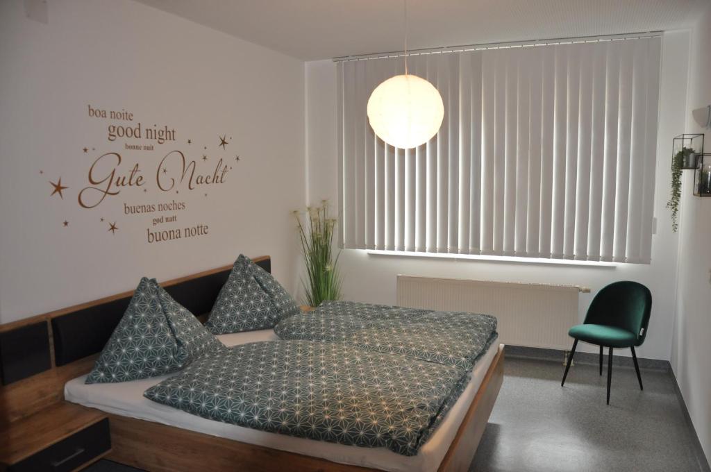 1 dormitorio con 1 cama y 1 silla verde en Apartment Auszeit en Kirchberg an der Pielach