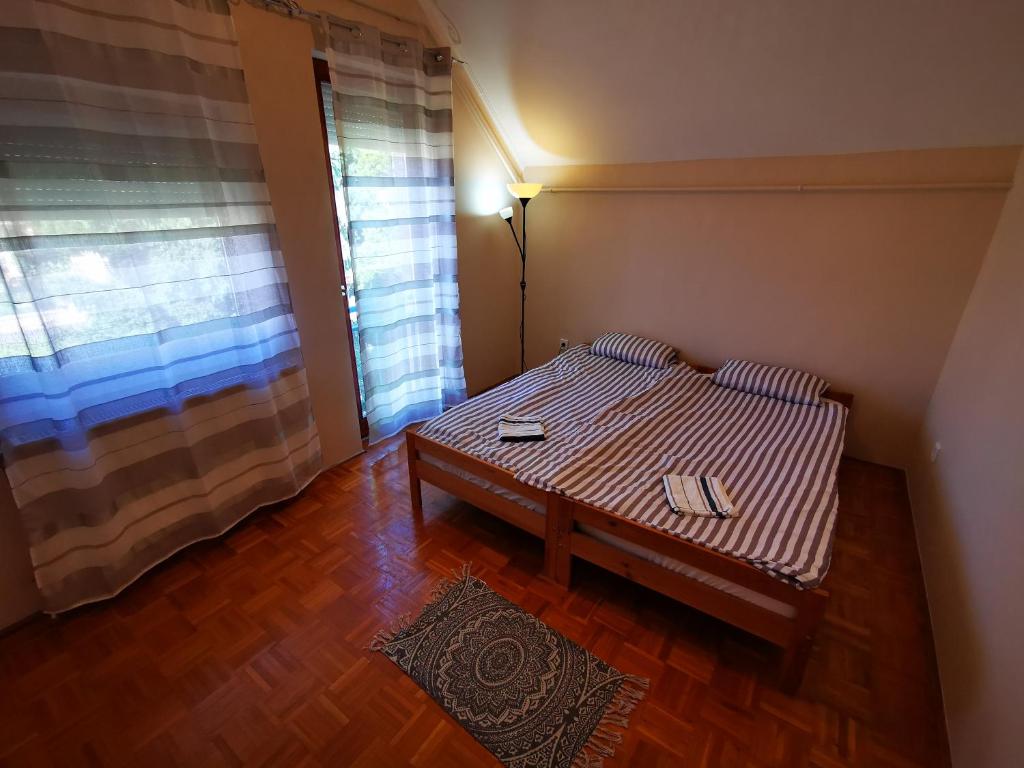 Habitación pequeña con cama y ventana en K20 Apartman, en Harkány