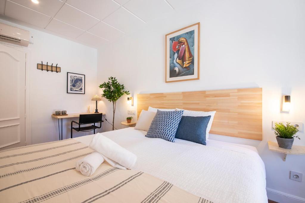 um quarto com uma grande cama branca e uma secretária em Marisol - Self Check-In Guesthouse - Adults only em San Sebastián