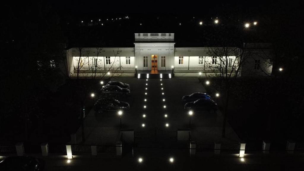 a white building with lights in front of it at night at Bogáthy Kúria Business Apartments in Nyírbogát