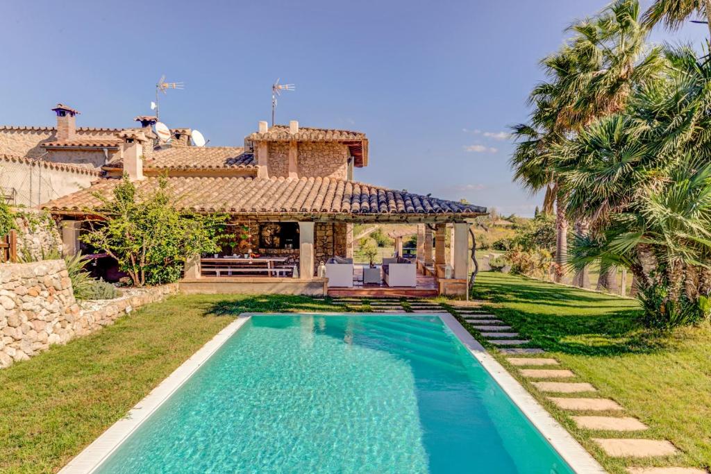 una casa con piscina frente a una casa en Villa Marina Cabanellas, en Pollensa