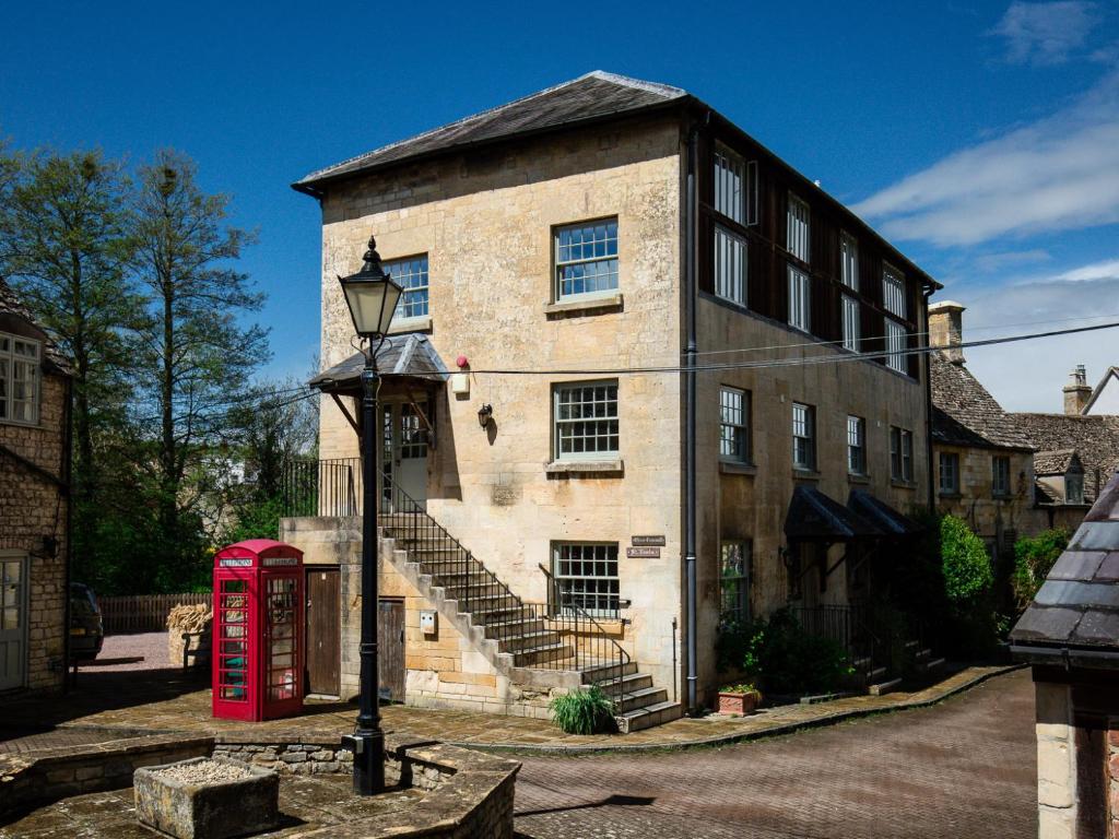 an old brick building with a red phone booth in front of it at Oliver Cromwell in Winchcombe