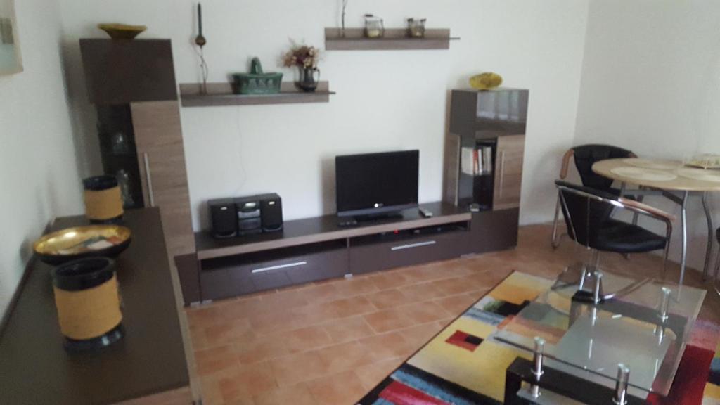 Una sala de estar con un televisor y una mesa. en Waldesruh, en Zinnowitz