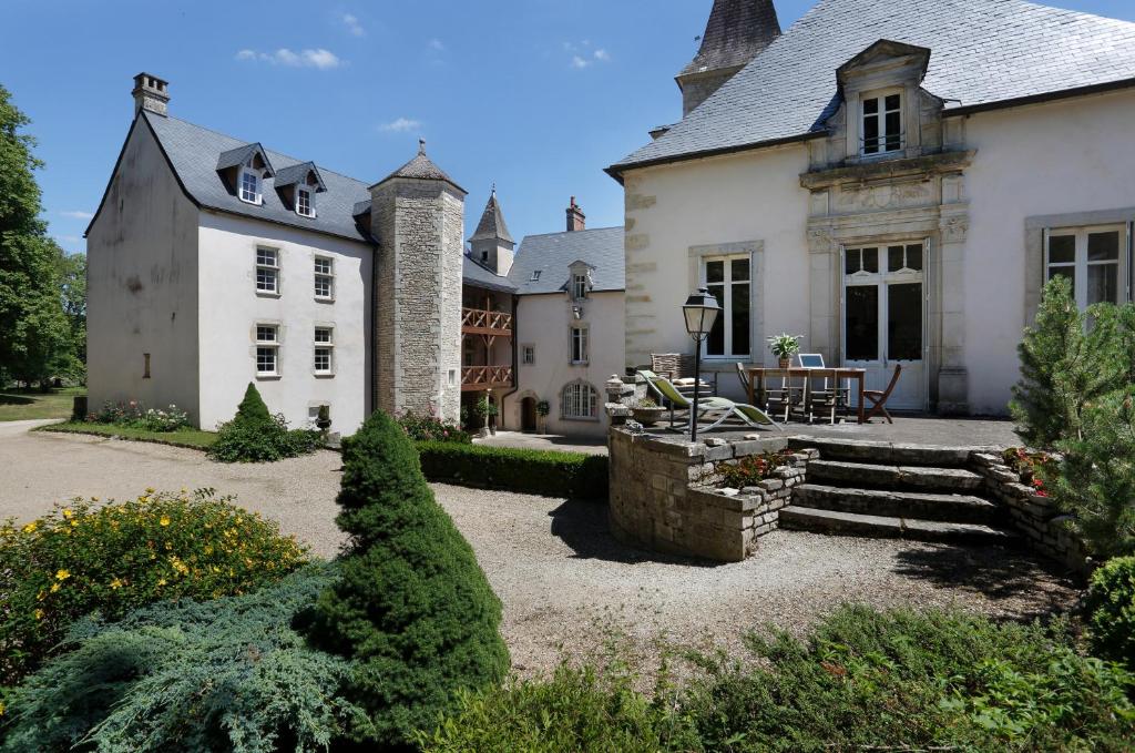 uma grande casa branca com uma mesa em frente em Château de Melin - B&B em Auxey-Duresses