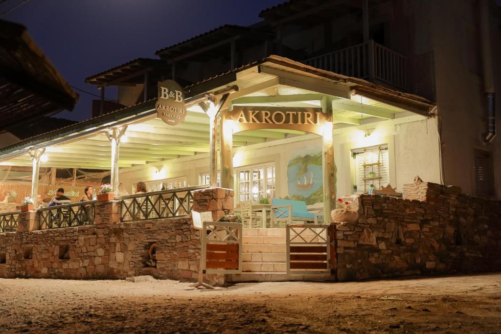 a restaurant with people sitting on a balcony at night at Akrotiri B&B in Pórto Káyio