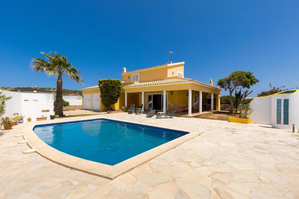 a villa with a swimming pool in front of a house at Sa Tramuntana in Cala en Blanes