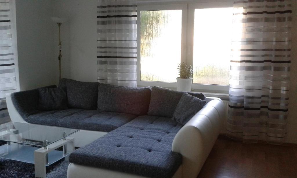 a living room with a couch and two windows at Ferienhaus - Roggentin in Roggentin