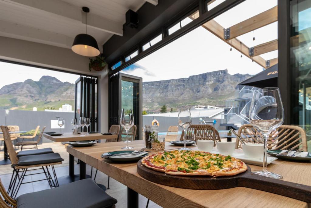 Cape Town的住宿－Kloof Street Hotel - Lion Roars Hotels & Lodges，坐在餐厅桌子上的比萨饼