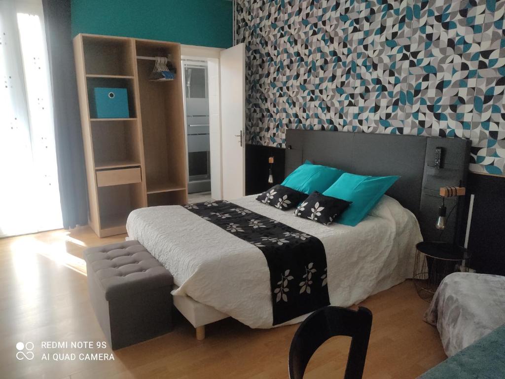 1 dormitorio con 1 cama grande con almohadas azules en Hôtel du Béarn en Bagnères-de-Bigorre