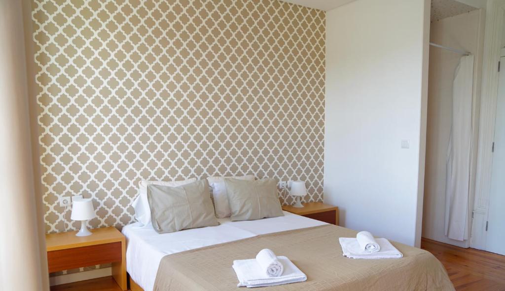 una camera da letto con un letto e due asciugamani di Hostel Casa do Pinheiro a Lagares da Beira