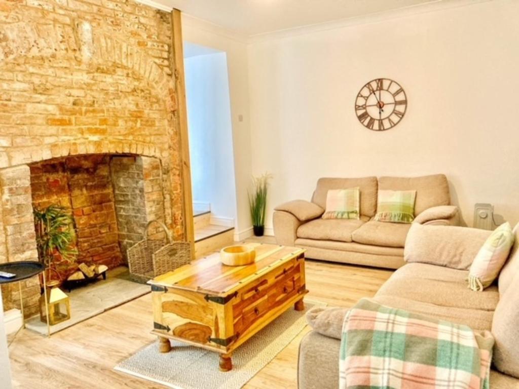 a living room with a couch and a fireplace at Stunning Renovated & Spacious 2 BR - 100m to beach in Little Haven