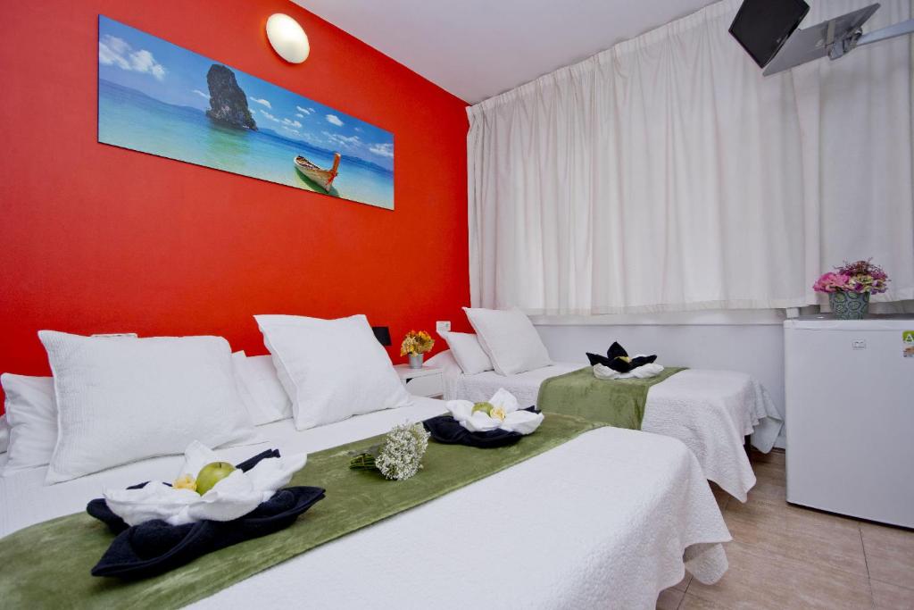 two beds in a room with red walls at Barcelona City North Hostal in Barcelona
