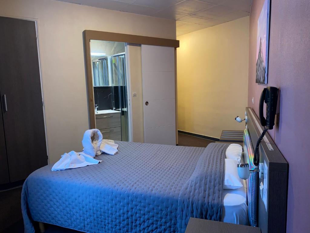 1 dormitorio con cama azul y espejo en Aero Hotel, en Issy-les-Moulineaux
