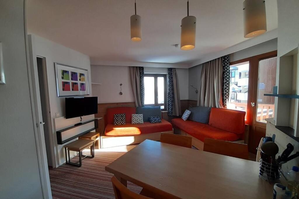 uma sala de estar com um sofá vermelho e uma televisão em La Tania 309 Le Britania em Courchevel