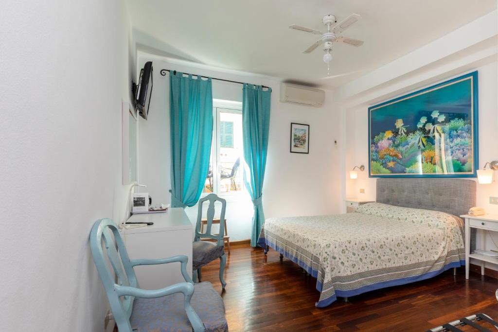 a bedroom with a bed and a desk and a chair at Albergo Nazionale in Portofino