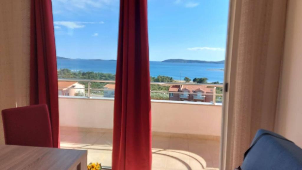 a room with a view of the ocean from a balcony at Apartment Ruby in Šibenik