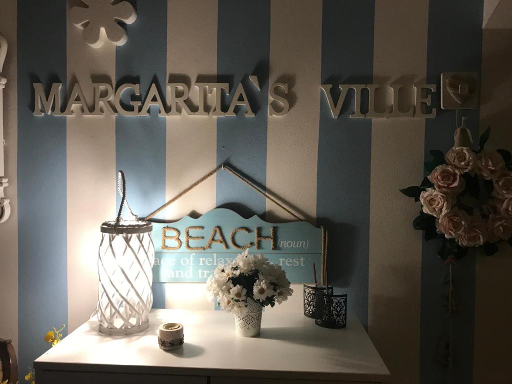 a table with a vase of flowers on a shelf at Margarita´s Ville in Costa Nova