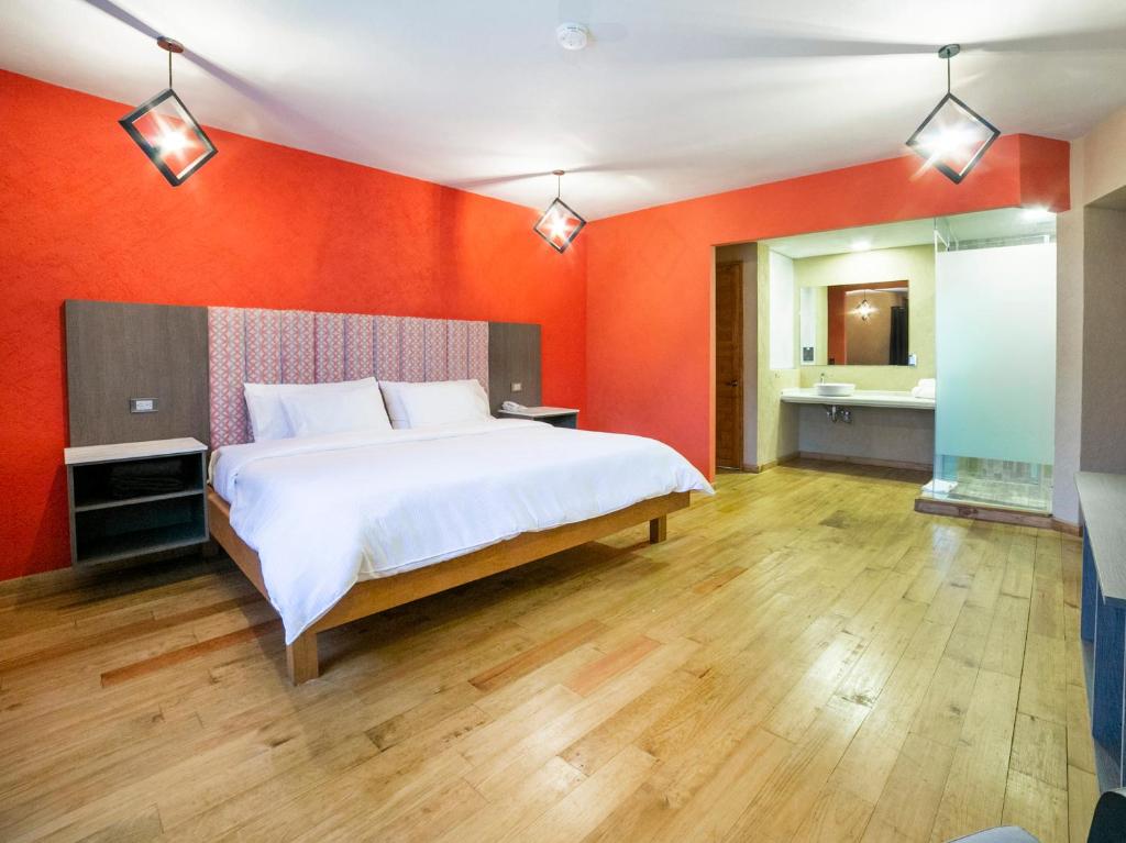 a bedroom with a large bed and a red wall at Hotel Casona de Minas in Mineral del Monte