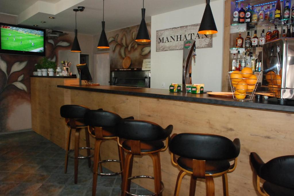 - un bar avec des tabourets en cuir noir dans un restaurant dans l'établissement Hotelik Manhatan, à Radzyń Podlaski