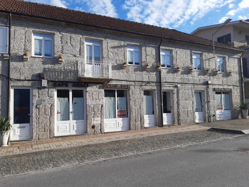 ein Steingebäude mit weißen Türen und Fenstern in der Unterkunft Casa Araci in Vieira do Minho