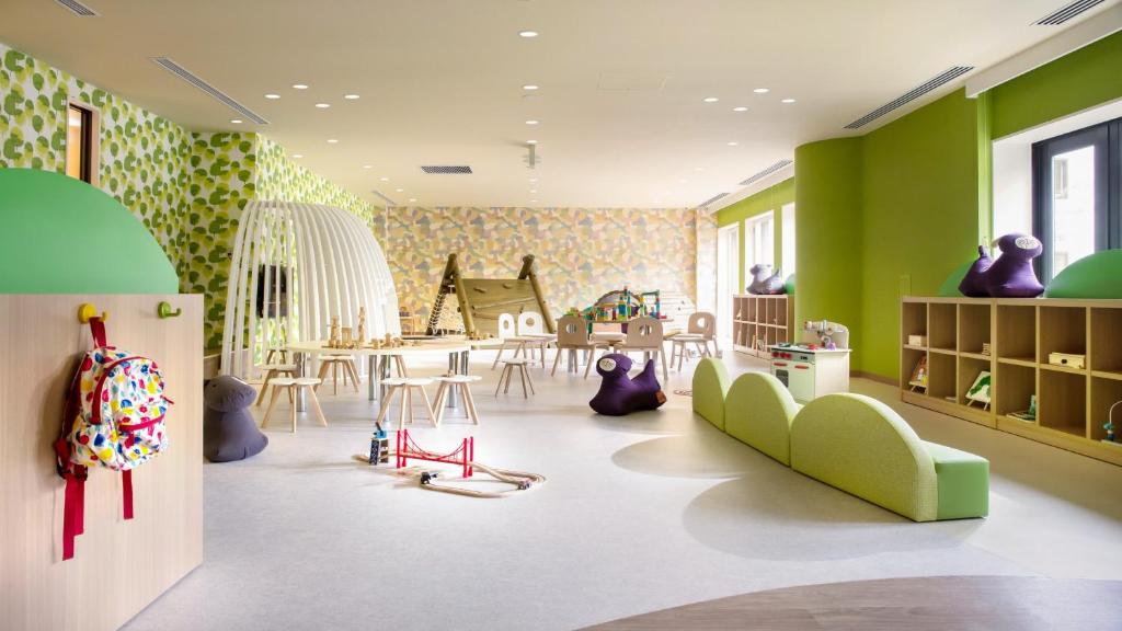 大町市Holiday Inn Resort Shinano-Omachi Kuroyon by IHG的儿童游戏室设有绿色的墙壁和桌椅