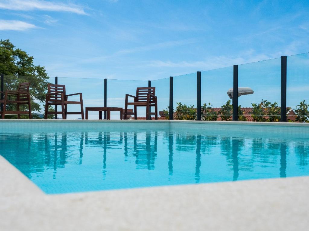a swimming pool with chairs and blue water at Apartments Bella Vista - Mlini in Mlini