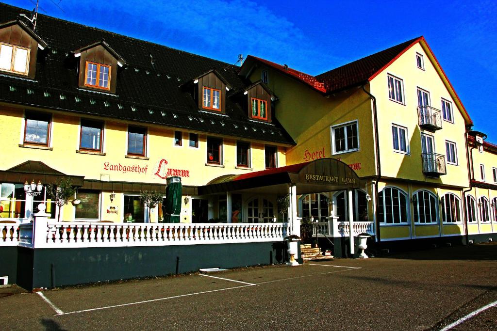 un gran edificio con una valla blanca delante de él en Landgasthof Hotel Lamm, en Laichingen