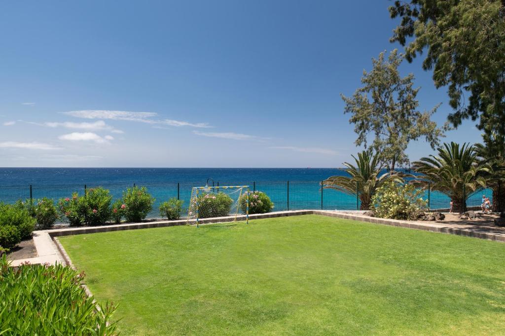 a park with a soccer field and the ocean at Alexandre Grand Teguise Playa in Costa Teguise
