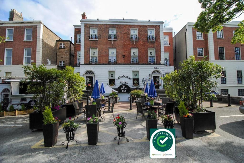 un hotel con mesas y sillas frente a un edificio en The Lansdowne Hotel, en Dublín