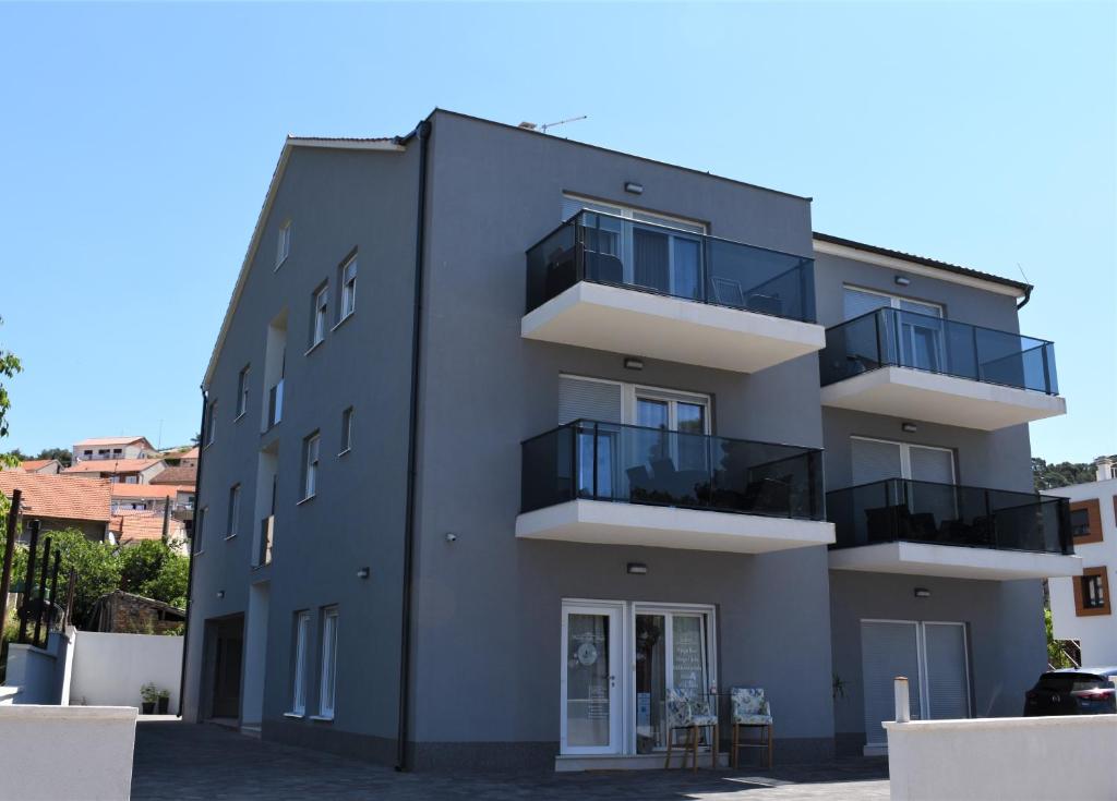 a building with balconies on the side of it at Apartments Rena in Šibenik