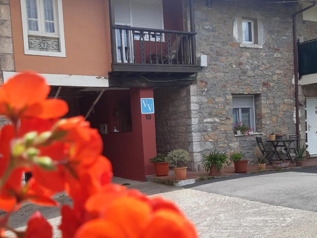ein Gebäude mit einem Balkon und Blumen davor in der Unterkunft Al Alba Alojamiento Rural in Illas