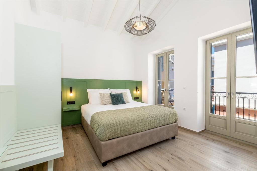 a bedroom with a bed with a green headboard at Suite Christina in Symi
