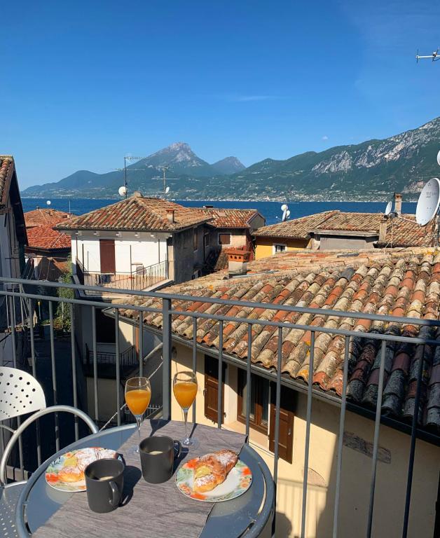 a table with two glasses of wine and pizza on a balcony at L'angolo di Giulia in Castelletto di Brenzone