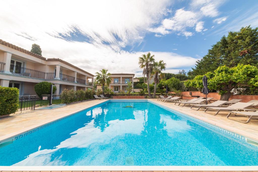 a swimming pool in a villa with lounge chairs at Hotel Brin d'Azur - Saint Tropez in Saint-Tropez