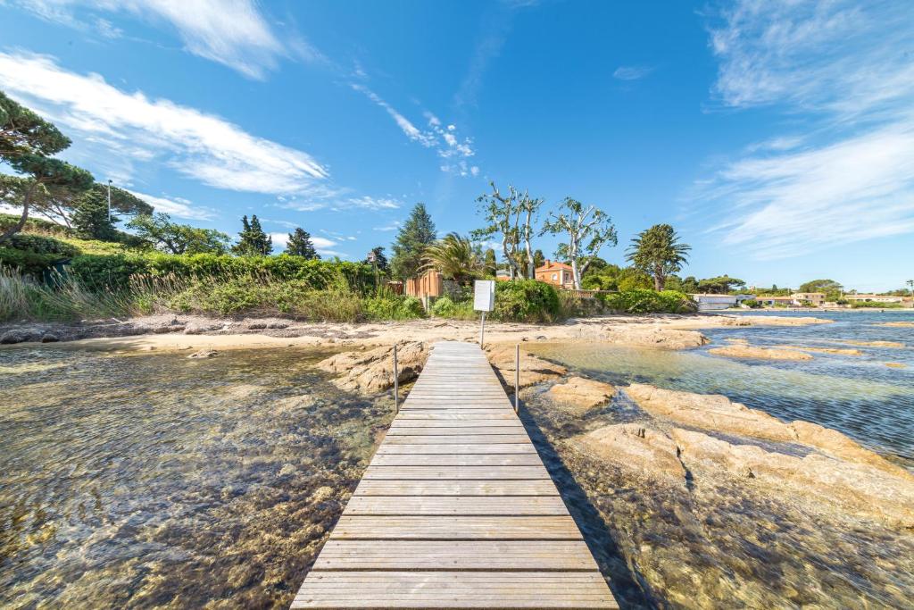 a wooden boardwalk stretches across a beach at Hotel Brin d'Azur - Saint Tropez in Saint-Tropez