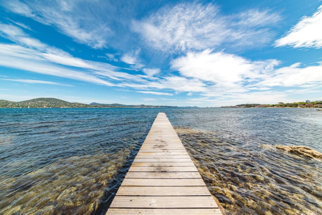 a wooden pier stretches out into a large body of water at Hotel Brin d'Azur - Saint Tropez in Saint-Tropez