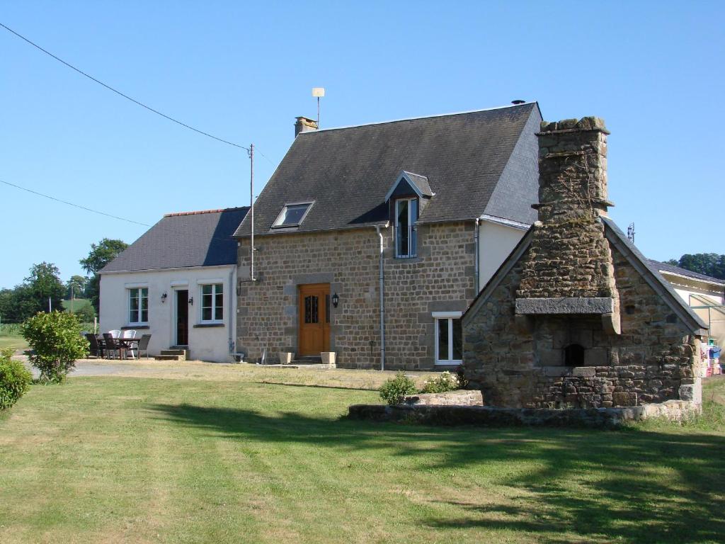 una casa in pietra con un camino in pietra in un cortile di La Blanche Roche a Sourdeval