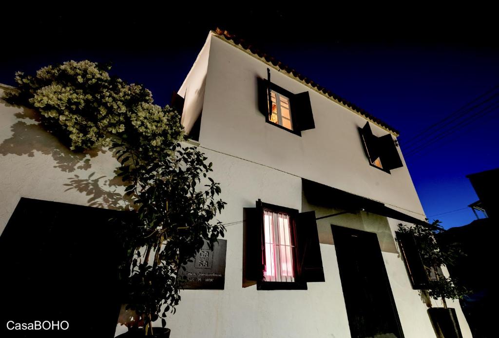 un edificio blanco con una ventana y un árbol en Casa BOHO en Alaminos