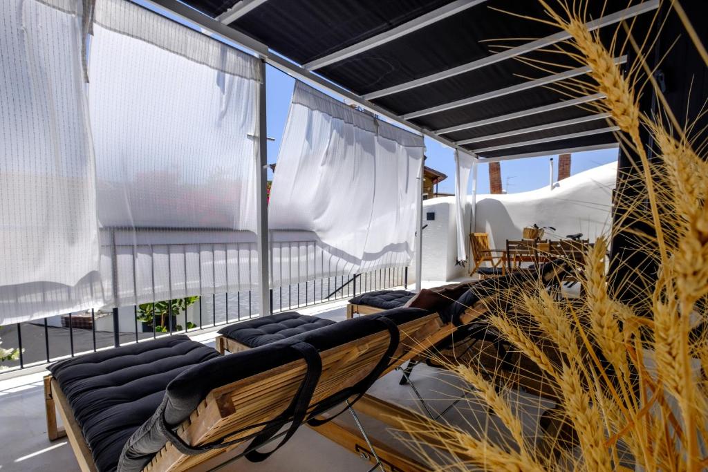 a room with chairs and curtains on a balcony at Casa BOHO in Alaminos