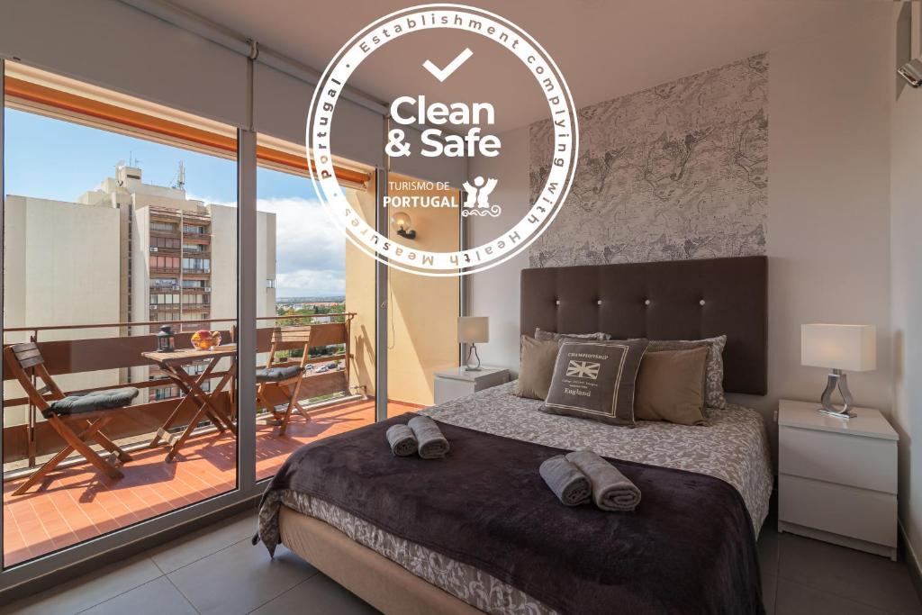 a bedroom with a bed with a view of a balcony at SUITE ON 7TH VILAMOURA THE BEST VIEW IN TOWN - 1Br in Quarteira