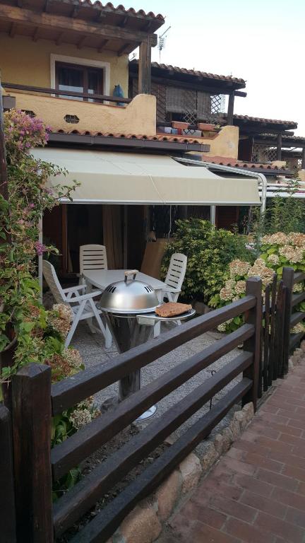une cour avec une table, des chaises et une clôture dans l'établissement residence approdo, à Cannigione