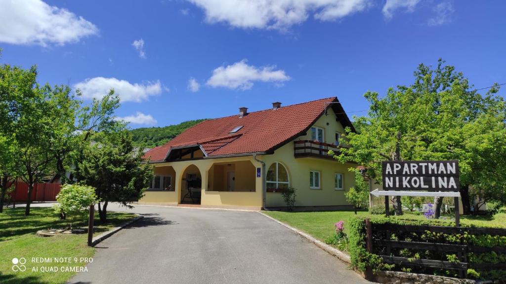 a house with a sign on the side of a road at Apartment Nikolina in Grabovac