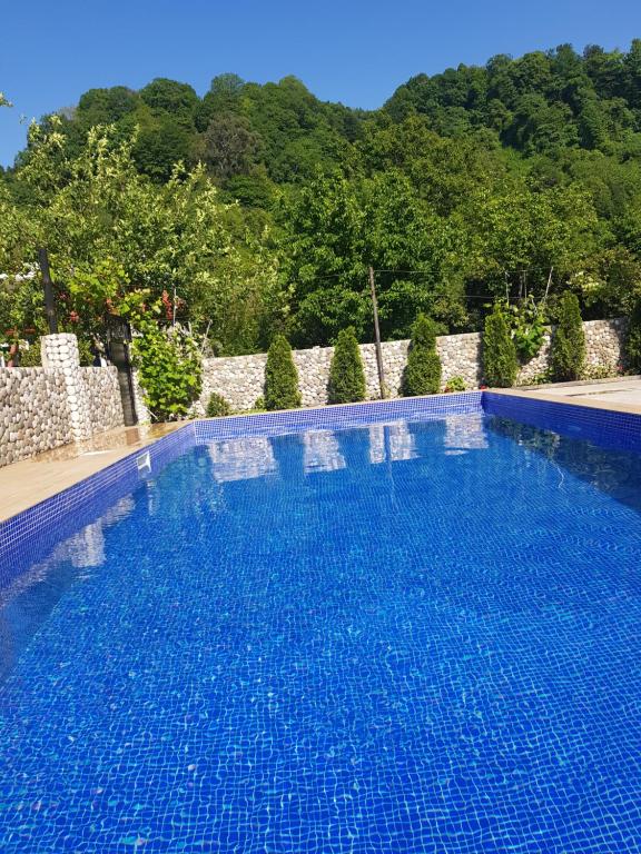 una gran piscina azul frente a una valla en Vizitori Hotel, en Gonio