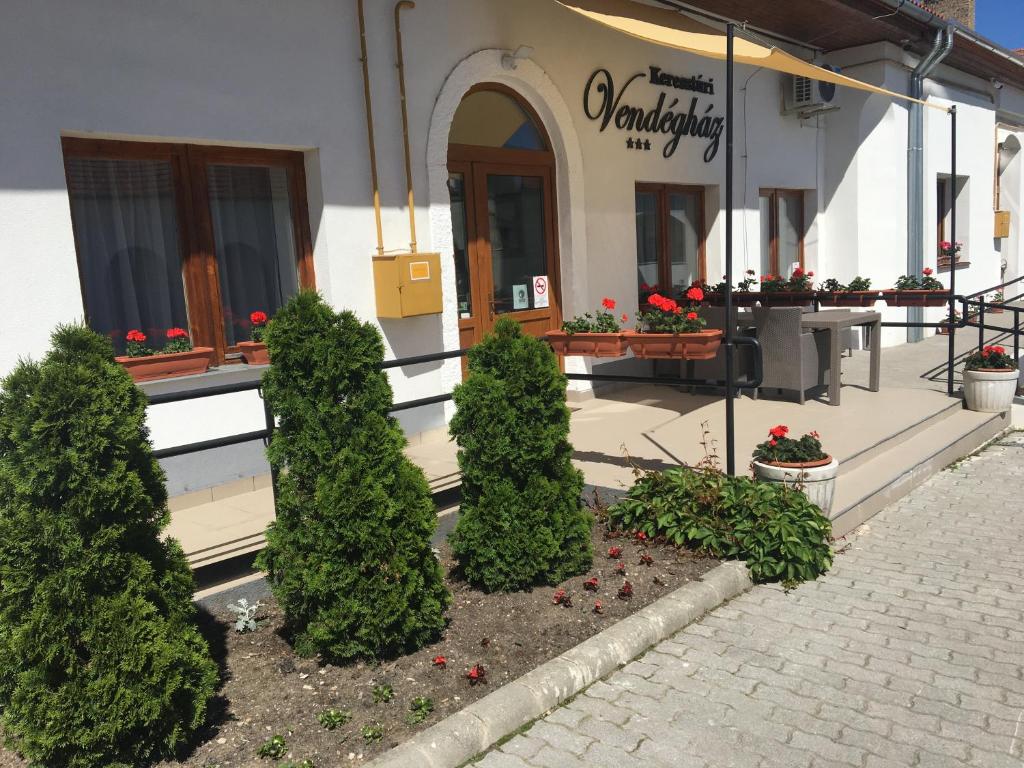 een gebouw met bomen en planten ervoor bij Keresztúri Vendégház in Bodrogkeresztúr