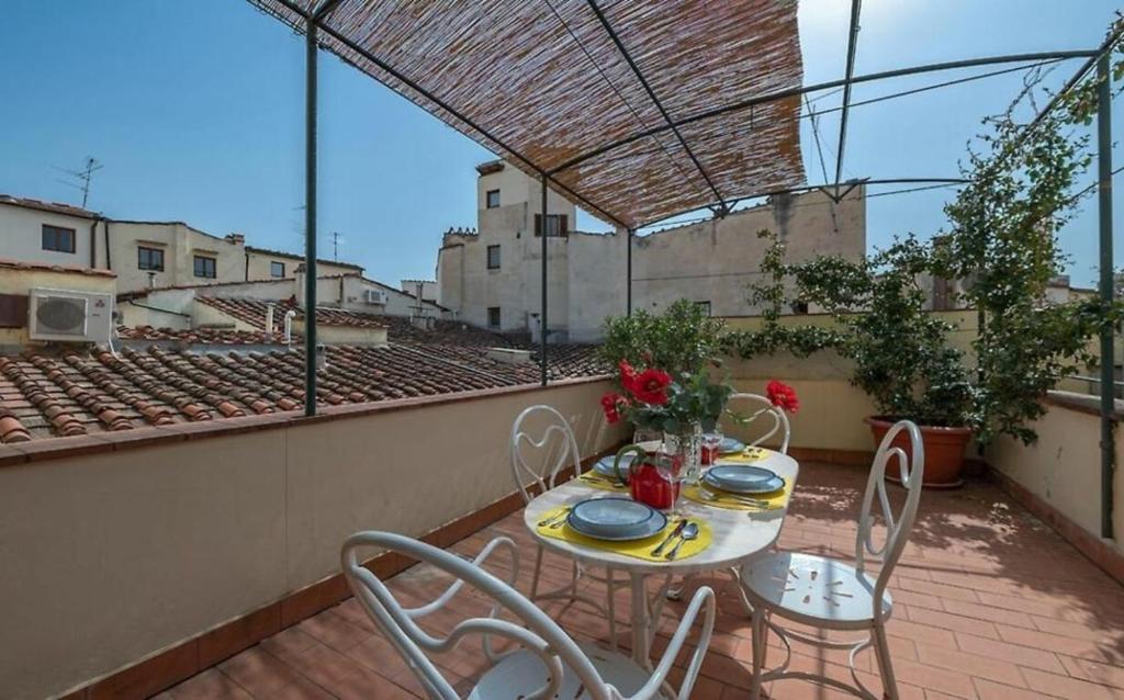 un patio con tavolo e sedie sul balcone. di Belvedere a Firenze